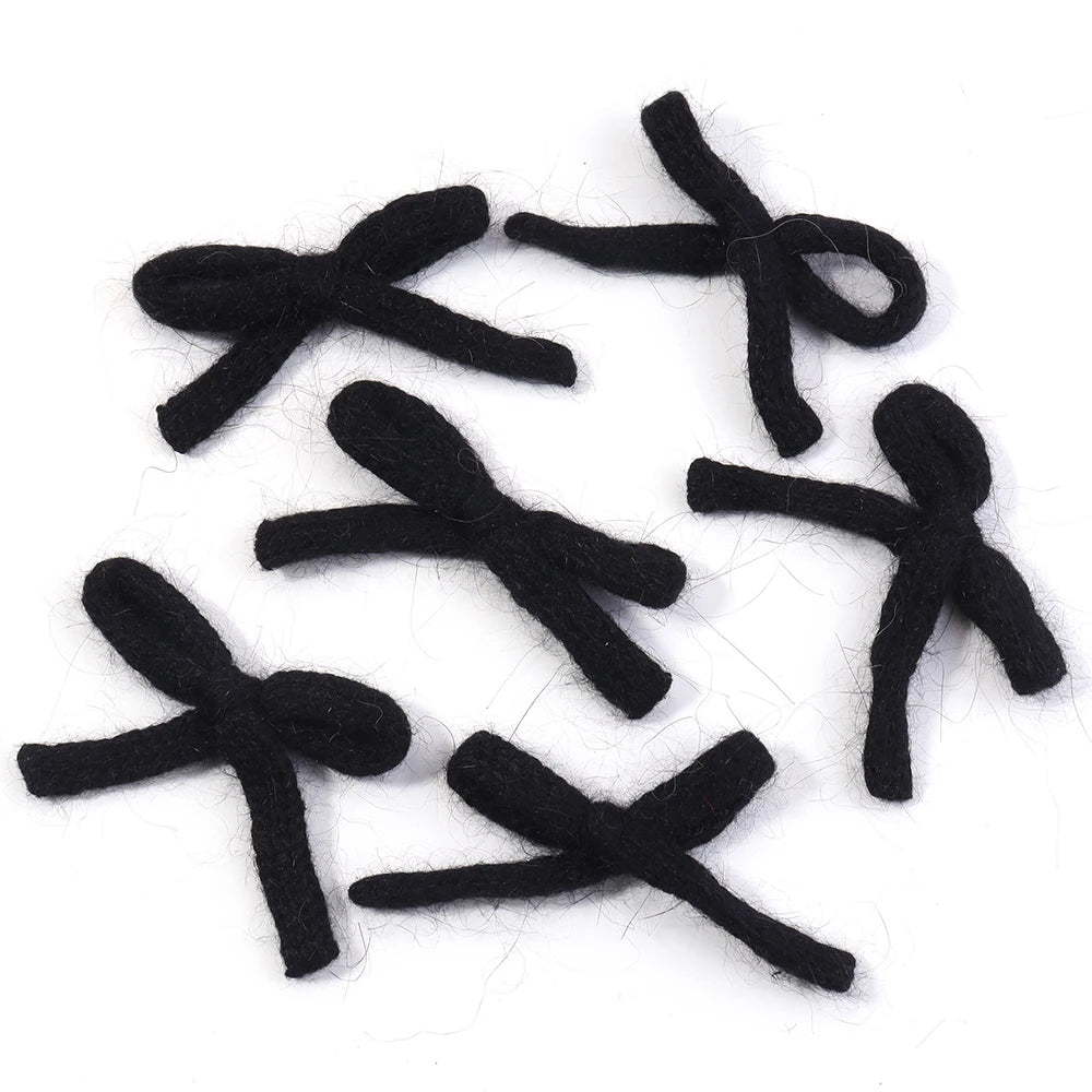 A set of six black knitted cotton bows or bowknots for crafting and decoration.