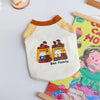 A cream-colored dog vest t-shirt with a yellow collar and a graphic featuring cookies and the text Bao Family.