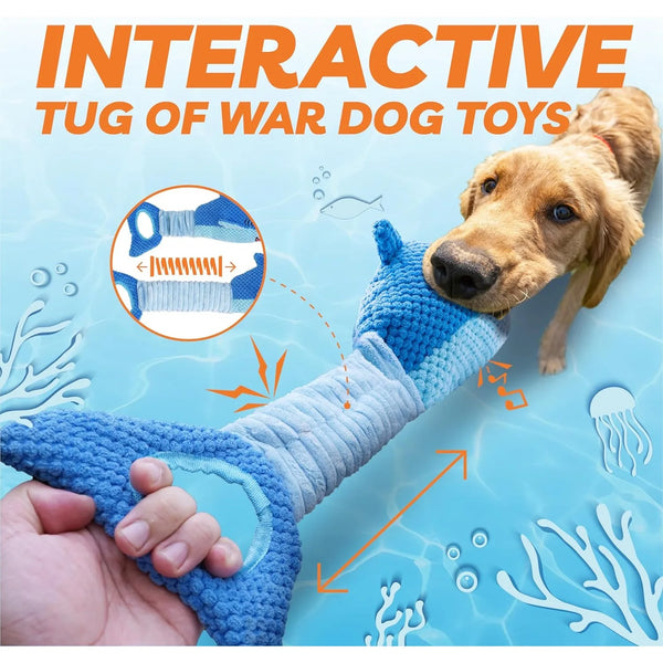A hand holds a blue dog tug toy with a shark design, showing its texture and squeaker feature.