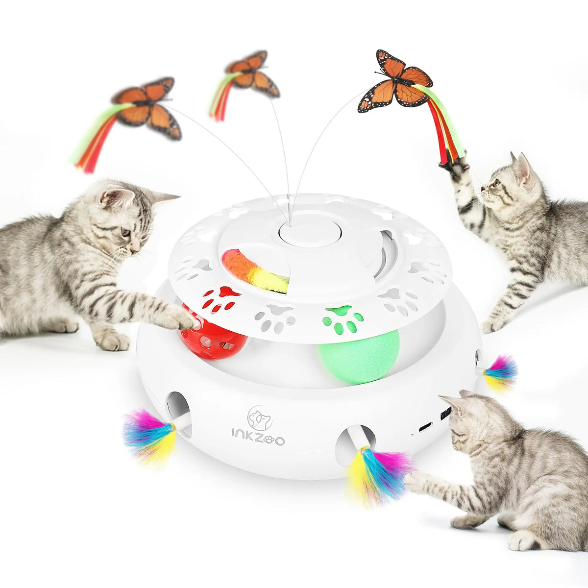 A cat playing with an interactive toy that shoots feathers, featuring a white base and colorful attachments.