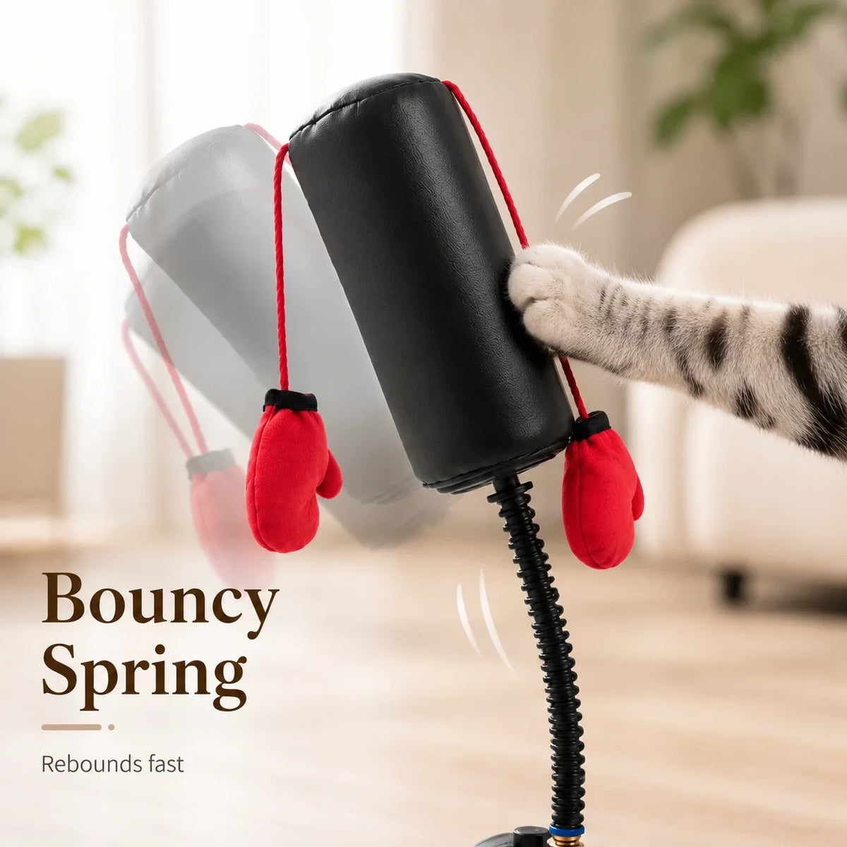 A black interactive cat boxing bag with a spring base and red boxing gloves is shown being bounced.