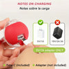 A hand holds a red self-moving cat toy ball with an attached charging cable and various power adapters.