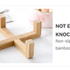Wooden bowl rack made of bamboo for holding pet bowls, shown on a white surface.
