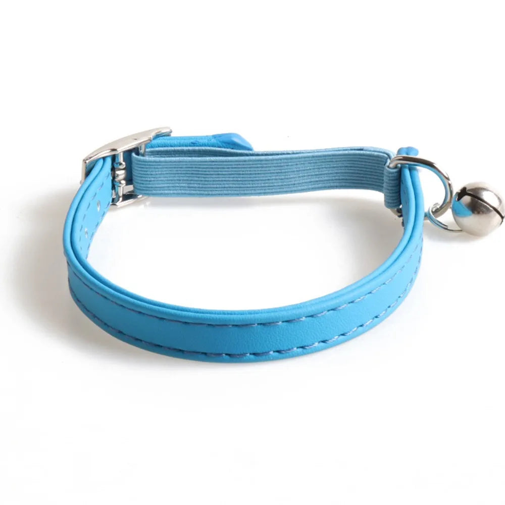 A light blue adjustable cat collar made of soft PU leather with an elastic webbing strap and a silver bell.