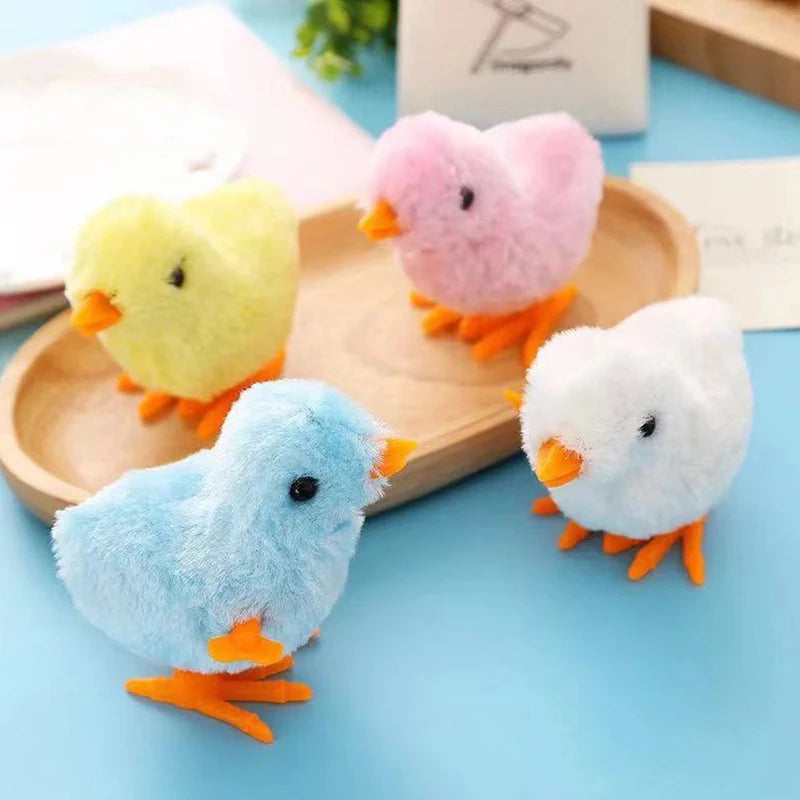 A collection of fluffy plush toys shaped like chicks in pink, yellow, and white sitting on a wooden tray.