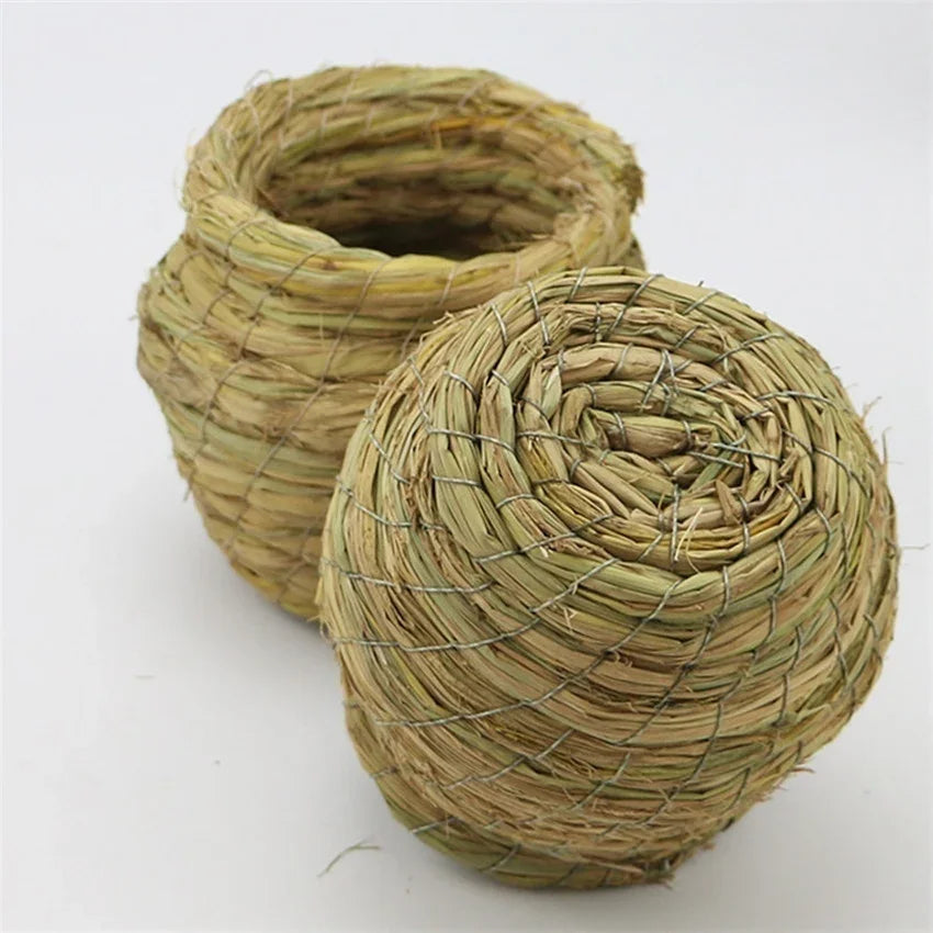 Handwoven straw bird nest for small birds, cylindrical in light tan color.