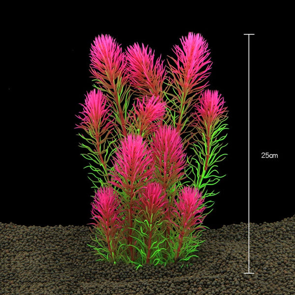 A cluster of vibrant pink and green artificial aquarium plants growing in dark soil.