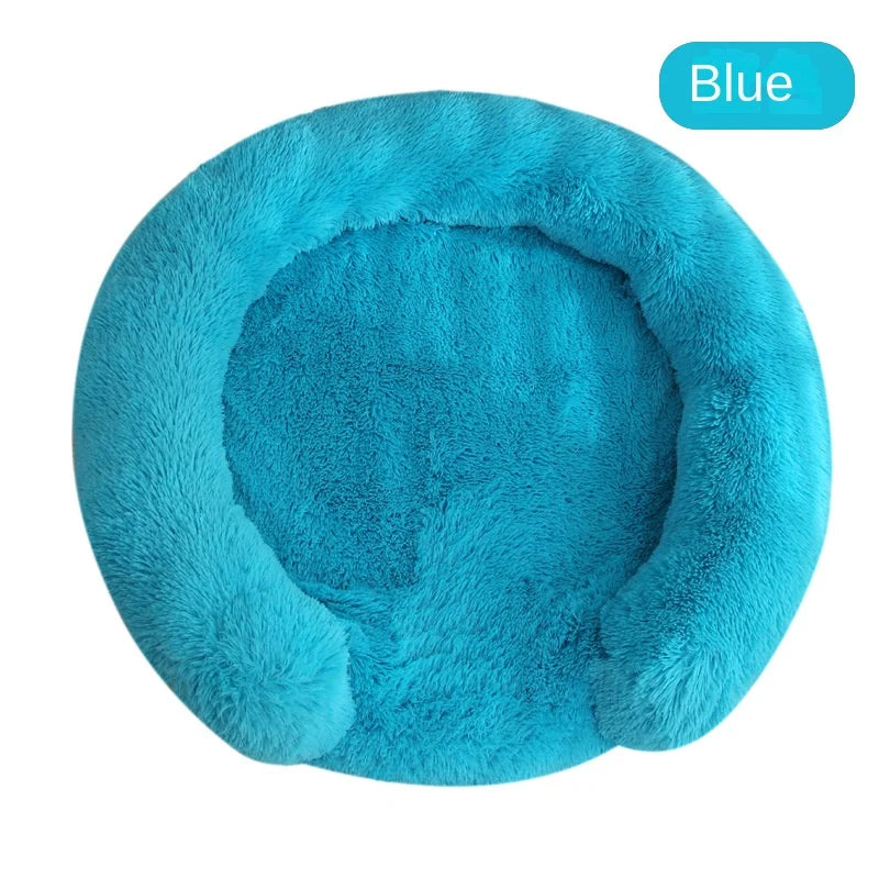 A round, fluffy blue dog bed with a removable cover.