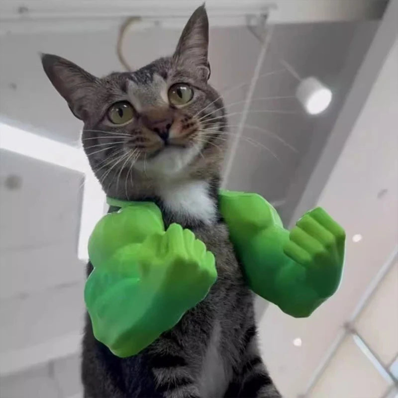A tabby cat wearing bright green 3D printed muscle arm accessories.