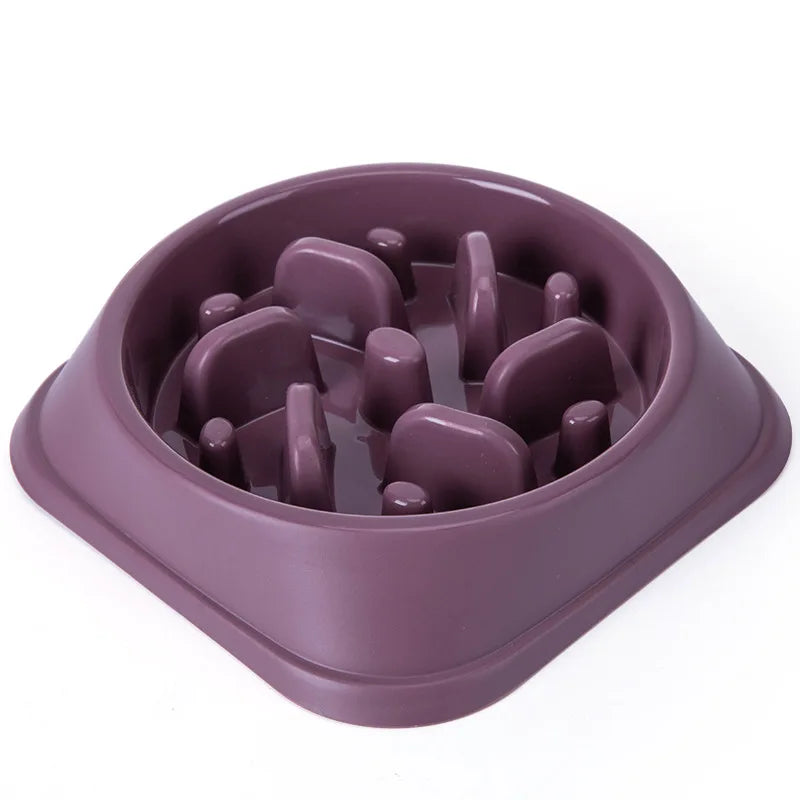 A purple non-slip slow feeder bowl for dogs with various puzzle shapes inside.