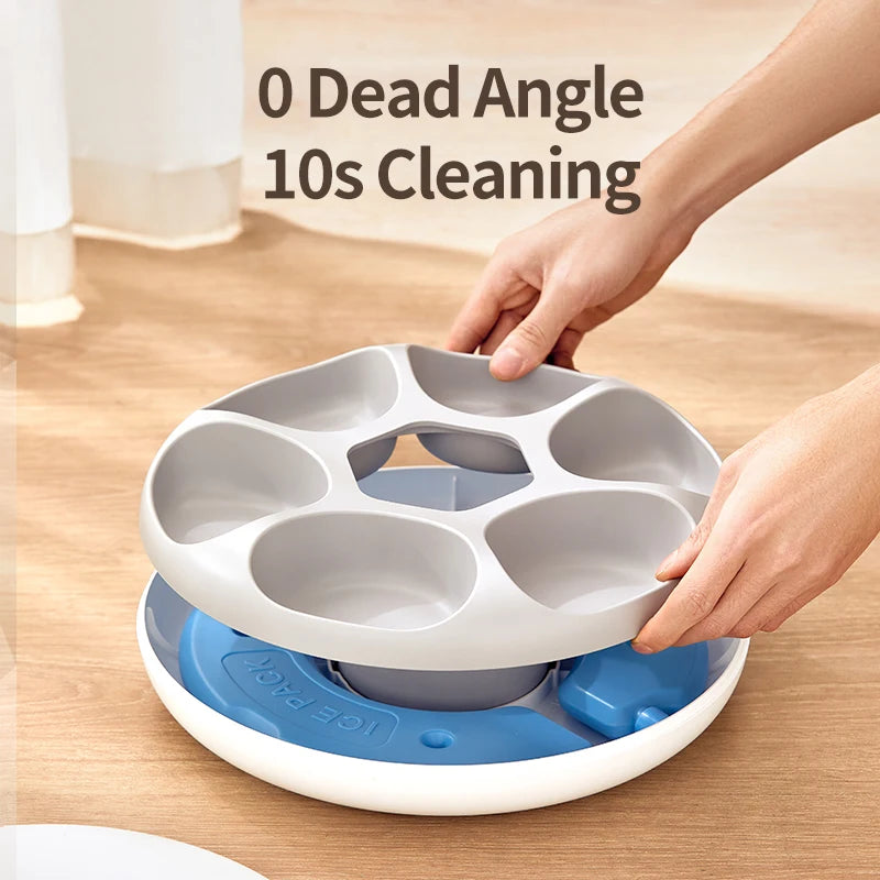 Une main tient un distributeur pour animaux de compagnie à 6 compartiments blanc et bleu avec des packs de glace sur une surf