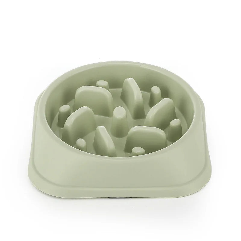 A light green non-slip slow feeder bowl for dogs with various puzzle shapes inside.