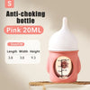 Pink 20ml silicone pet nursing bottle with anti-choking valve shown on a wooden surface