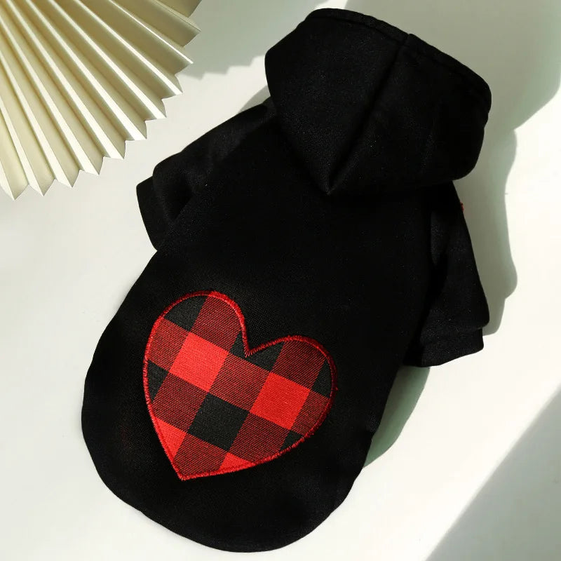 Black dog jacket with a red plaid heart patch on the chest