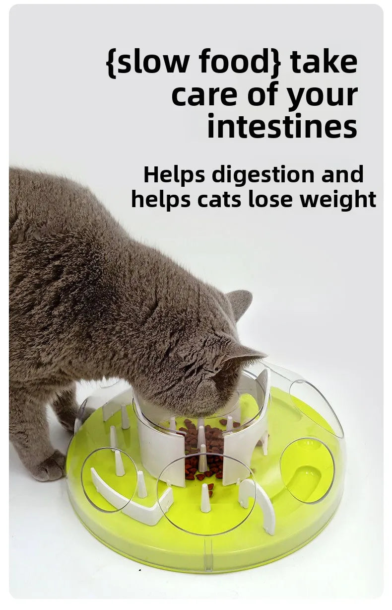 A gray cat is interacting with a yellow puzzle feeder bowl designed to help with digestion and weight loss.