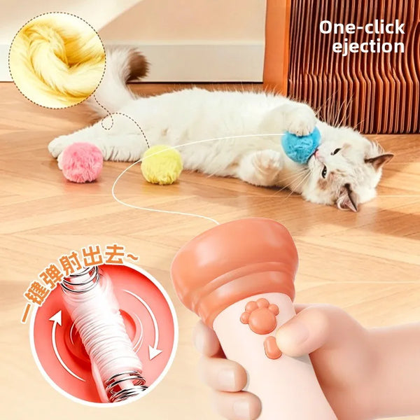 A white cat is shown relaxing while a hand holds an orange electric interactive cat teaser wand with an auto-retractable toy.