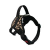 A black dog harness with a leopard print fabric and reflective stitching.