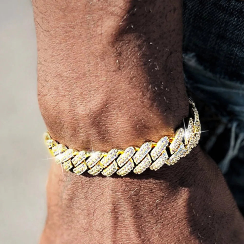A close-up of a gold iced-out Cuban link bracelet with rhinestone pavé worn on a wrist.