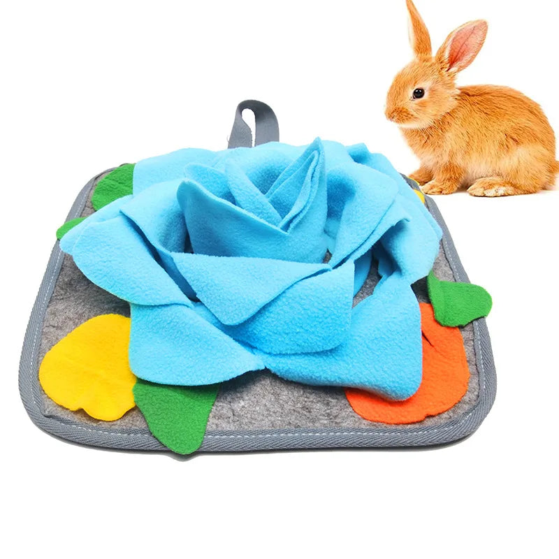 Blaues Stoffblumen-Schnuffematte mit bunten Stoffstücken und einem kleinen braunen Hasen daneben.
