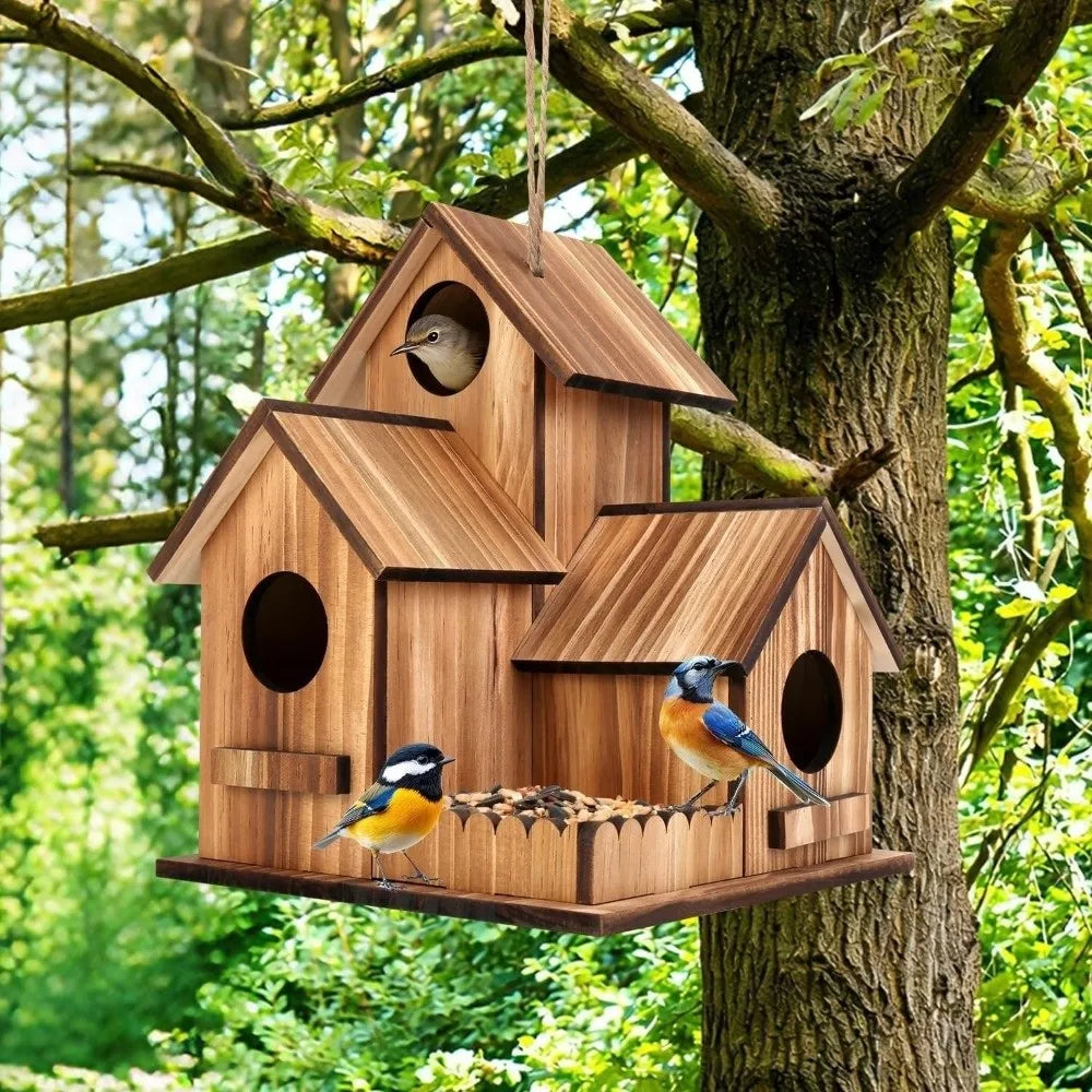 A rustic wooden bird house with multiple entrances is hanging from a tree branch in a lush green forest setting.