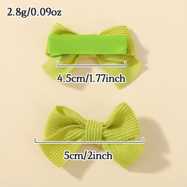 A bright lime green knitted ribbon hair bow clip with a rectangular plastic bar, shown against a light background.