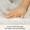 A hand is gently touching a fluffy gray pet bed, demonstrating air-skin comfort technology.