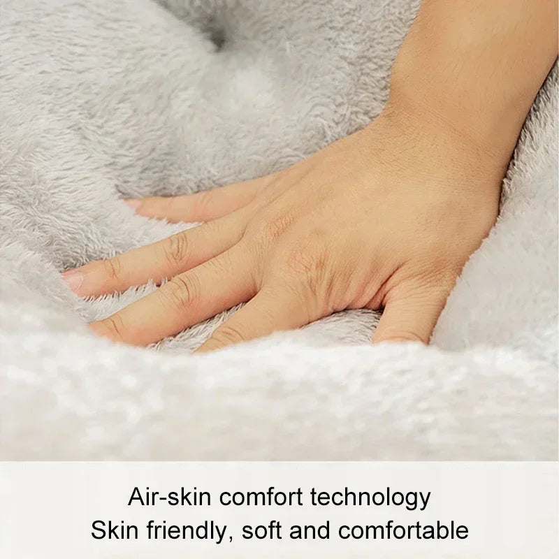 A hand is gently touching a fluffy gray pet bed, demonstrating air-skin comfort technology.
