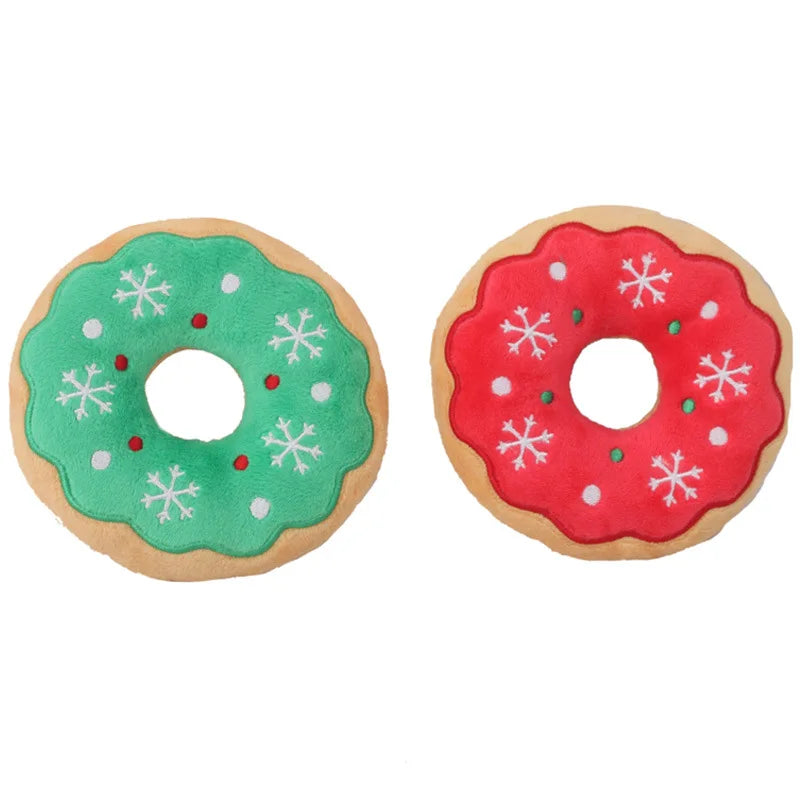 Two round plush squeak toys shaped like holiday donuts, one green and white, the other red with white snowflake designs.