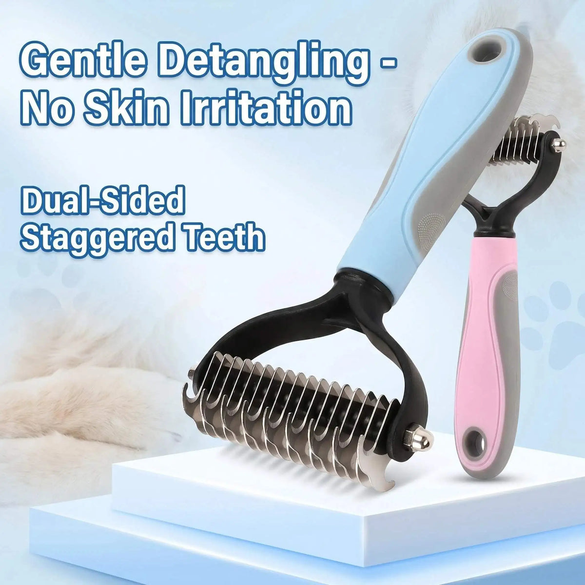 A dual-sided stainless steel pet detangling comb with a light blue handle and pink accents resting on a white surface.
