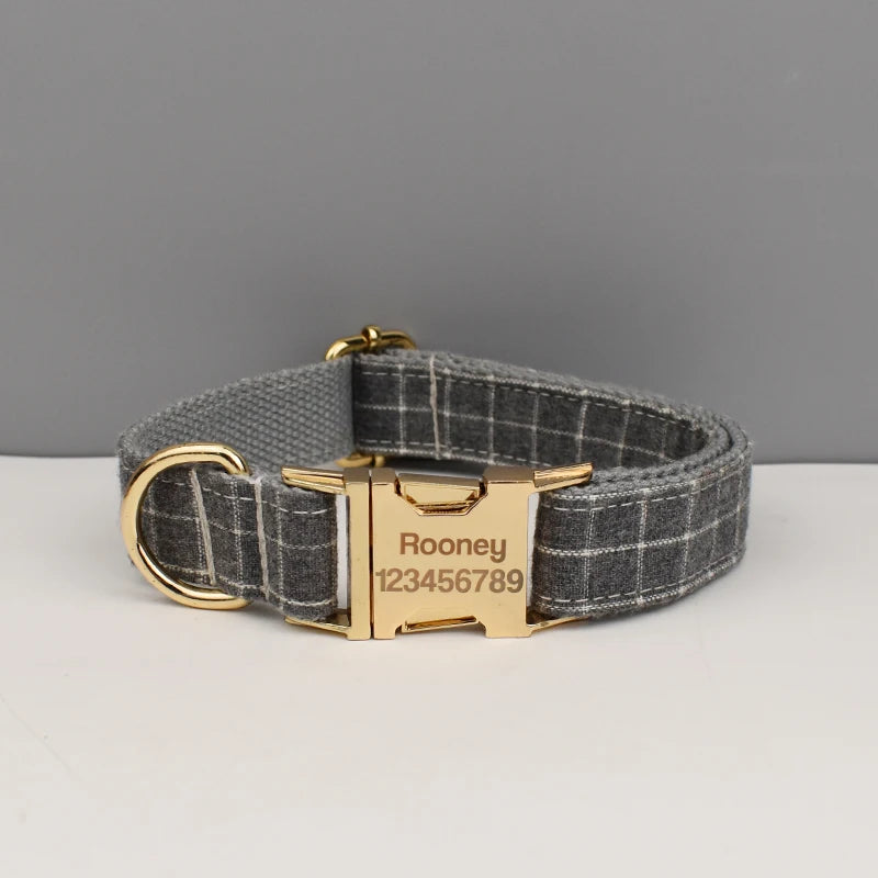 A gray and black plaid dog collar with a gold buckle and a personalized tag engraved with the name Rooney