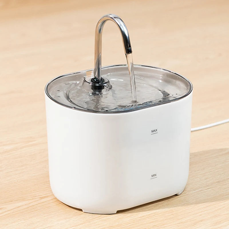 A white cat water fountain with a stainless steel faucet is shown on a wooden surface.
