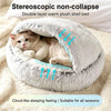 A fluffy, double-layer warm plush shell bed for a cat is shown nestled in a soft, cream-colored blanket.