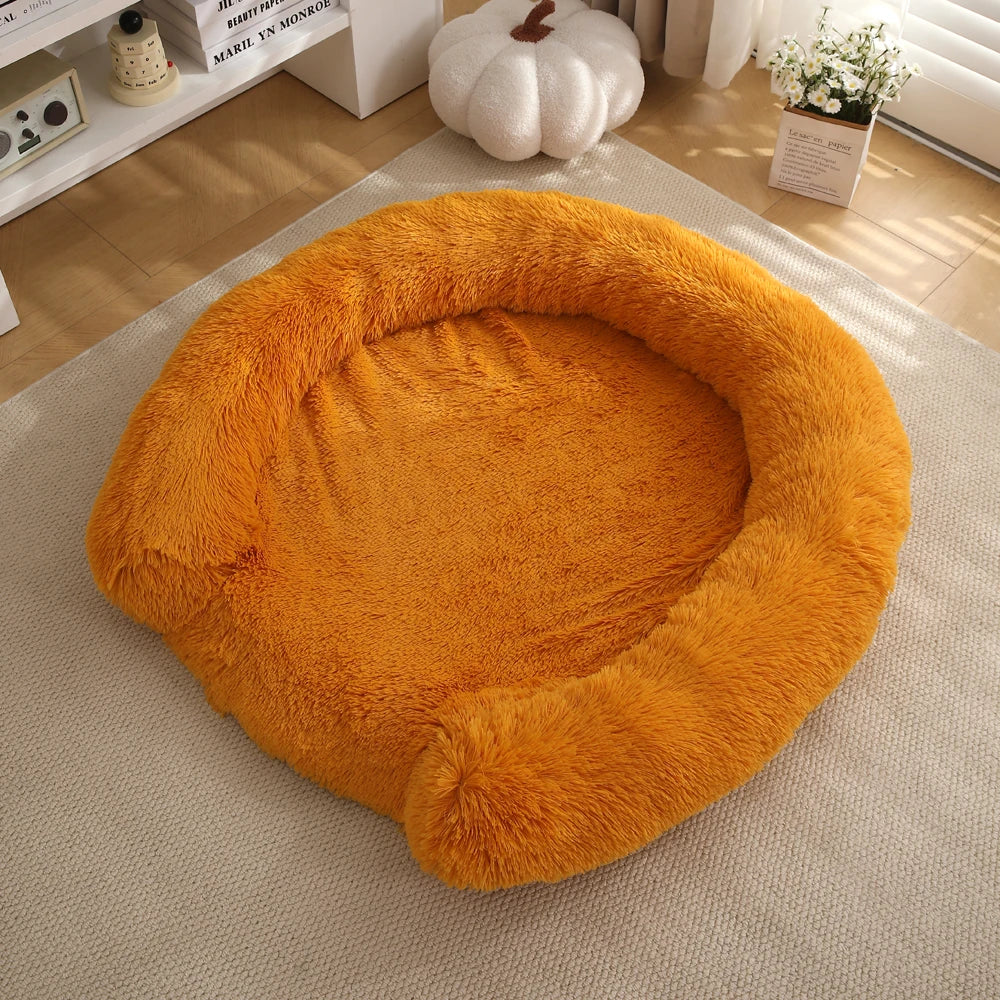 An orange fluffy round dog bed resting on a light beige carpet.
