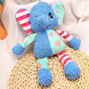 A blue elephant plush toy with pink accents sitting on a woven mat.
