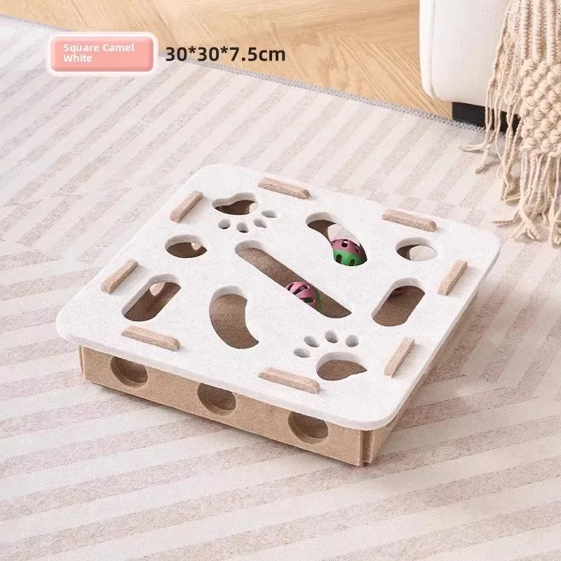 A white square felt puzzle toy with various holes and a small green object is shown on a light-colored rug.