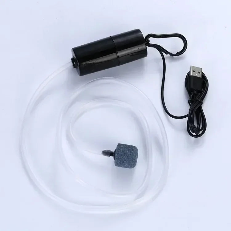 A black USB-powered aquarium air pump with a clear tubing and a small gray component.