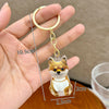 A gold-colored keychain featuring a puppy-shaped pet hair keepsake charm.