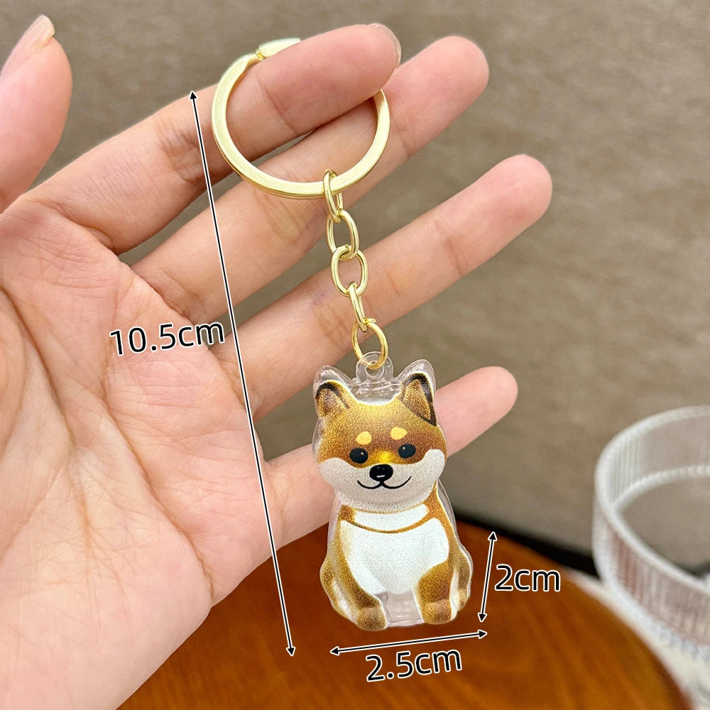 A gold-colored keychain featuring a puppy-shaped pet hair keepsake charm.