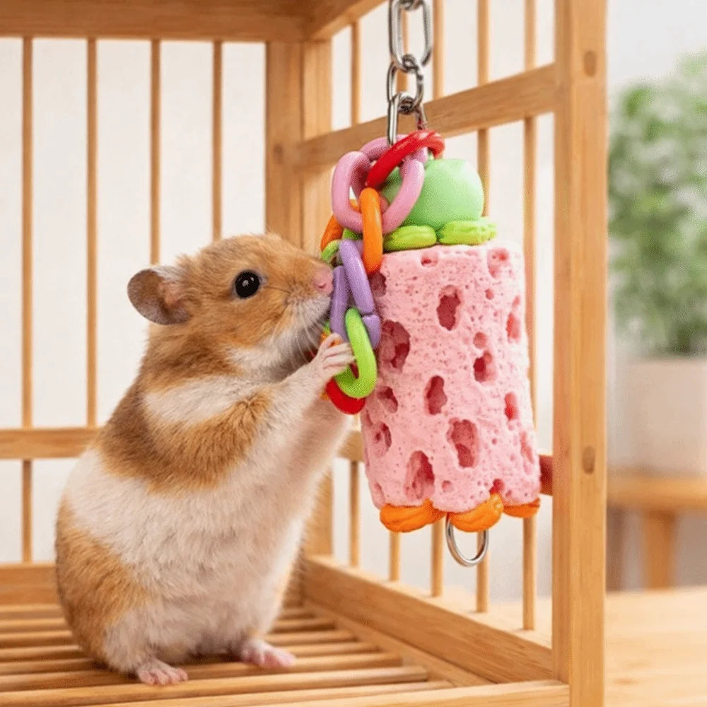 A small brown rodent is interacting with an interactive hanging chewing toy for pets inside a wooden enclosure.