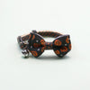 An adjustable Halloween pet collar featuring a black fabric bow tie and a silver bell.