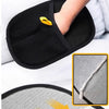 A black pet hair removal grooming glove with a yellow tip is shown being used on a hand.