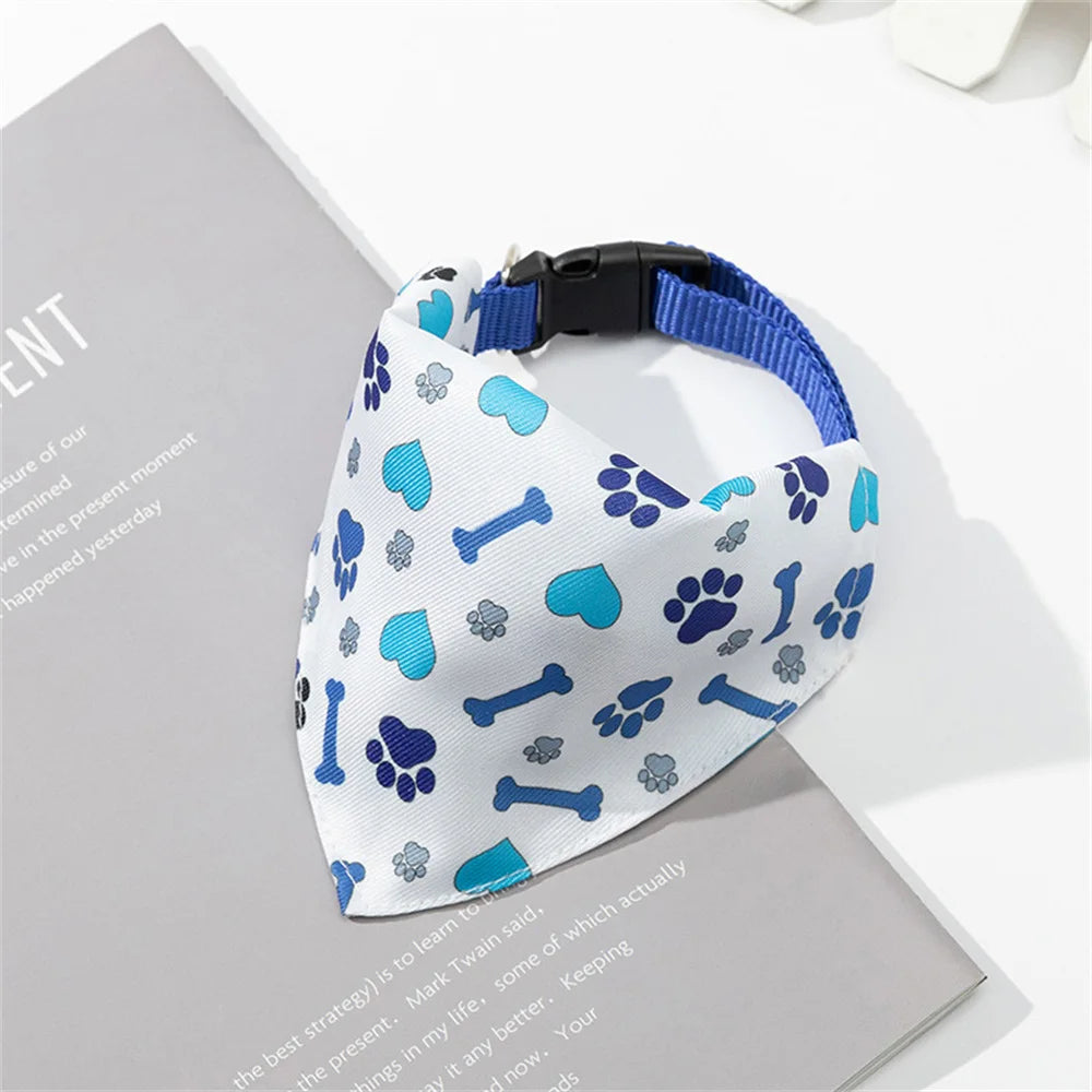 A blue and white patterned triangle bandana with a black strap is displayed on a gray background.