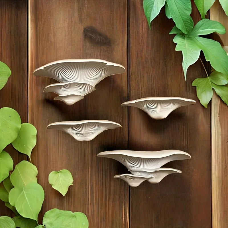 A collection of beige mushroom-shaped decorative storage racks mounted on a dark wooden surface surrounded by green leaves.