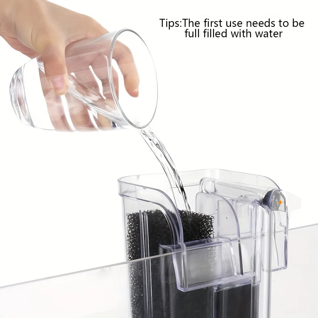 A hand pours water into a clear plastic mini aquarium filter for its first use.