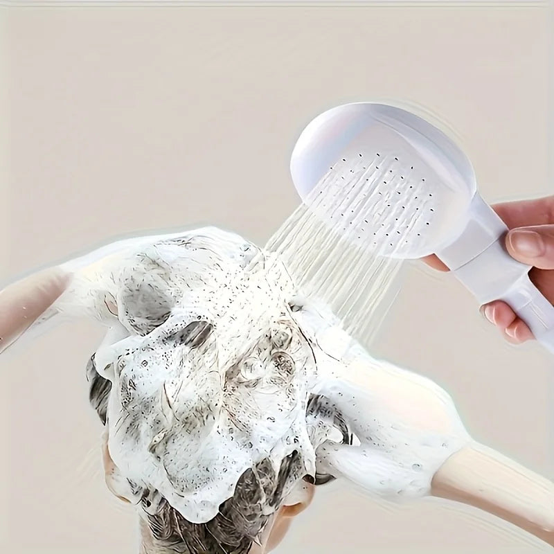 A hand is using a white 360° portable faucet sprayer with a long hose to wash hair.