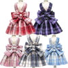A plaid dress for a dog featuring various patterns and colors like red, purple, and blue.