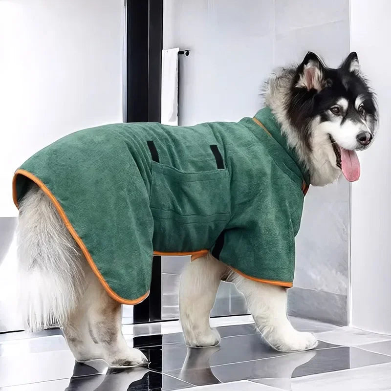 A fluffy black and white dog wearing a green quick-dry absorbent pet bathrobe.