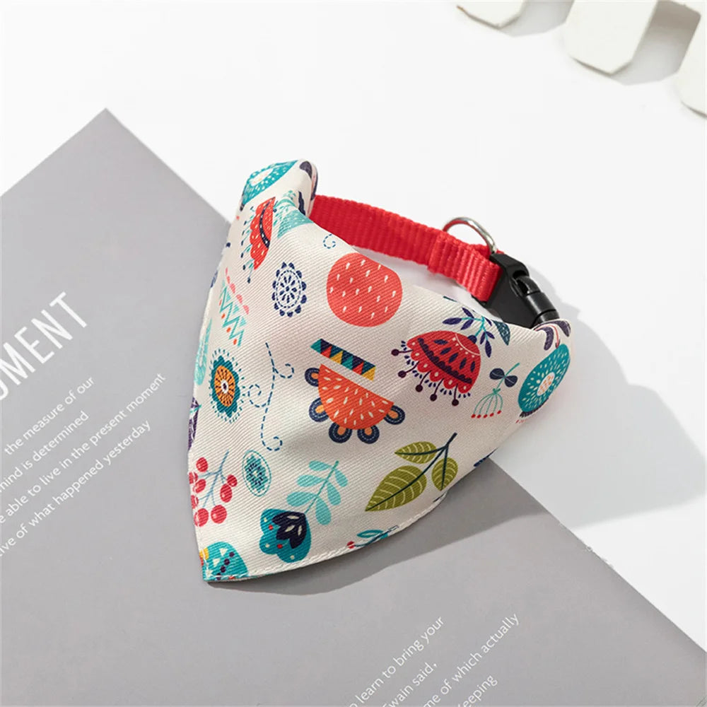 A printed pet collar with a matching bandana featuring floral and geometric patterns, shown on a gray background.