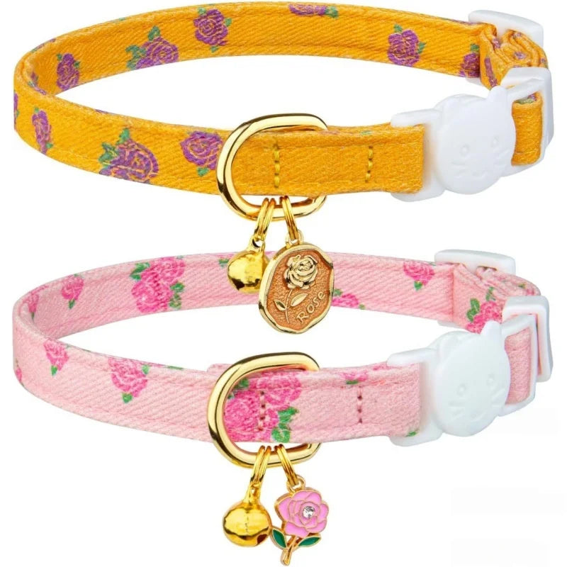 A yellow floral breakaway cat collar with a white tag and a pink floral bell on a pink strap.