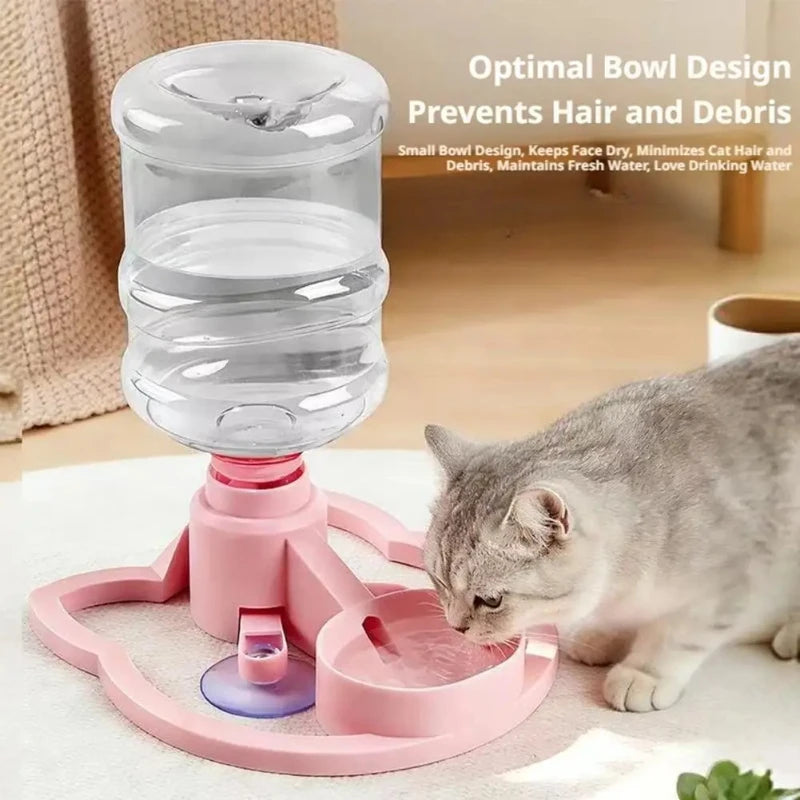 A pink gravity cat water dispenser with a clear bowl is shown next to a tabby kitten drinking water.